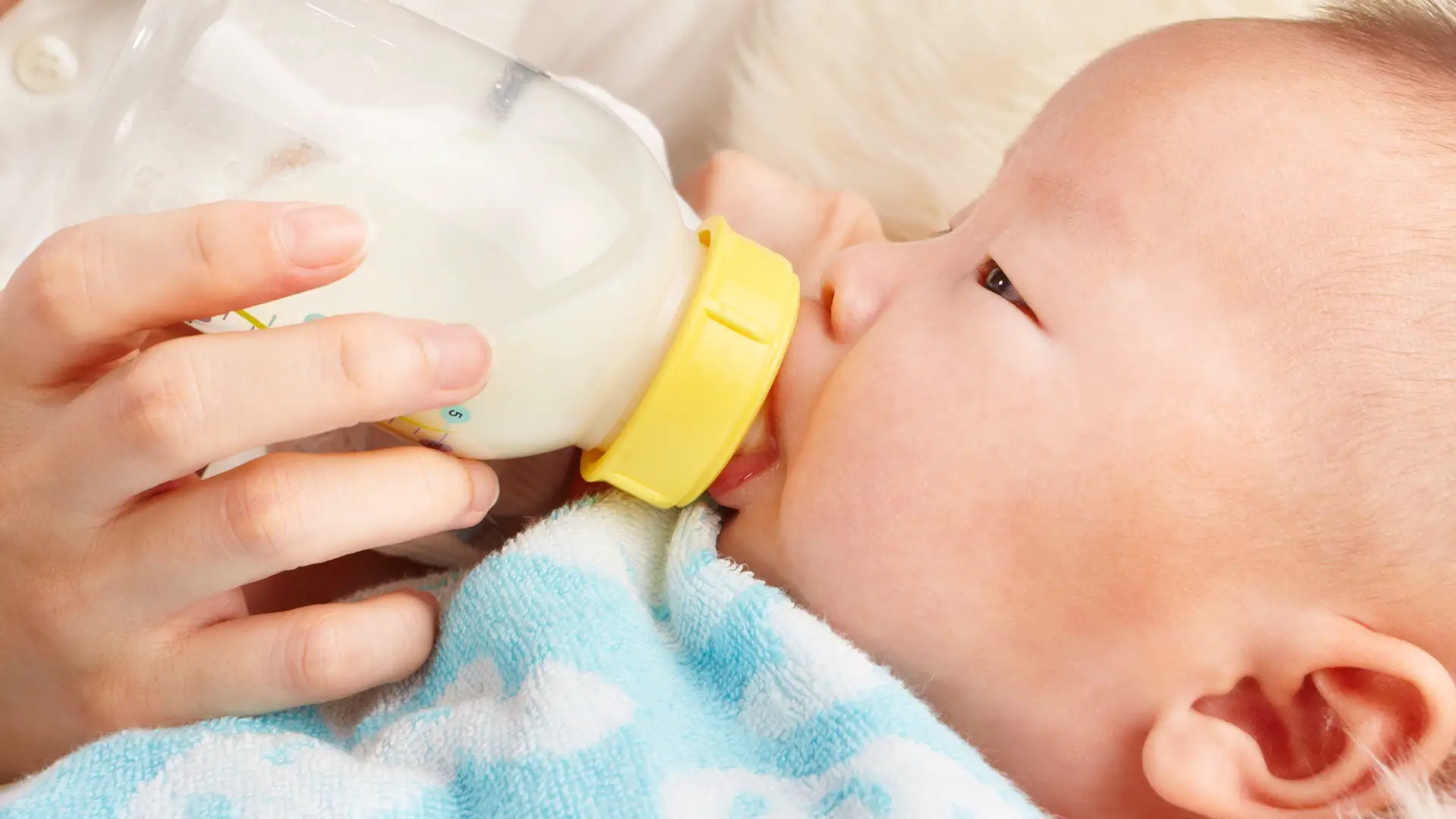 baby drinking milk on a feeding bottle
