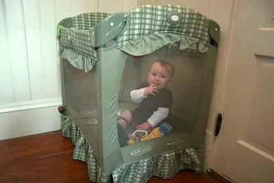 toddler sitting in his green crib