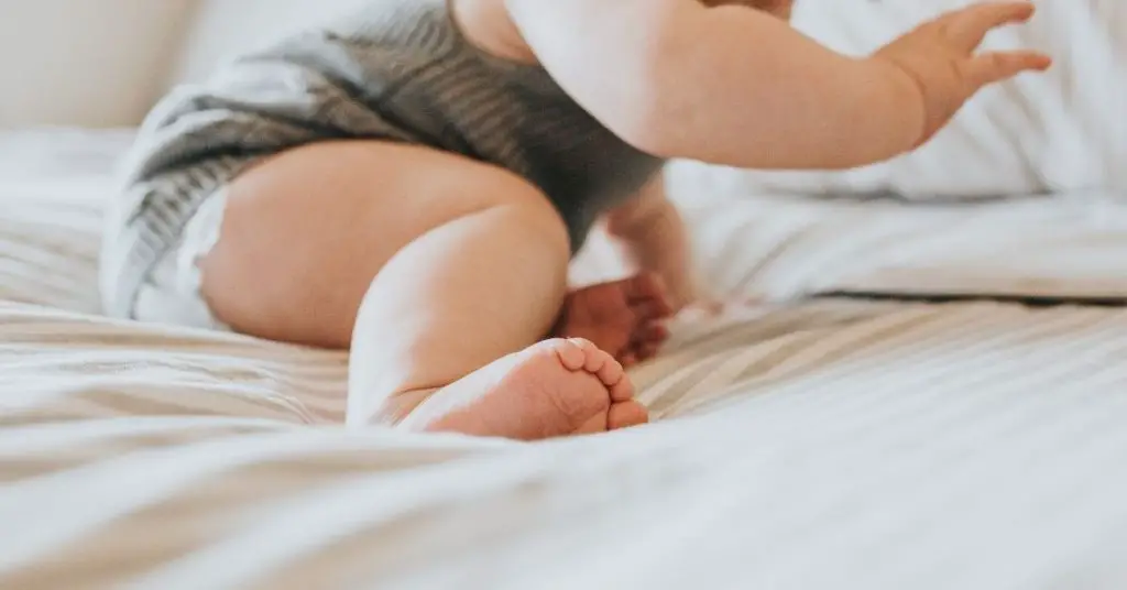 Image of a chubby baby playing on a comfortable white mattress