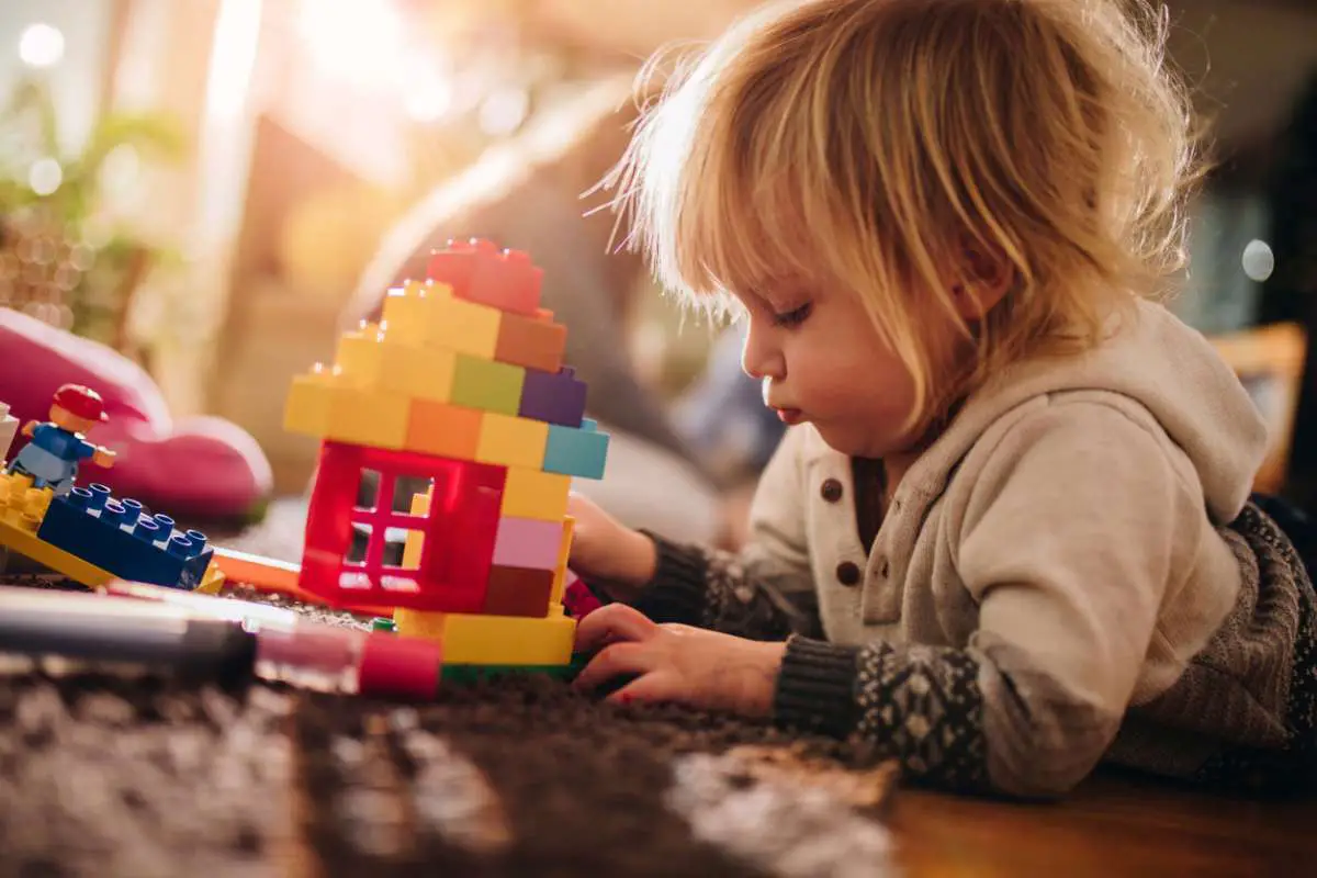 toddler playing lego on the floor