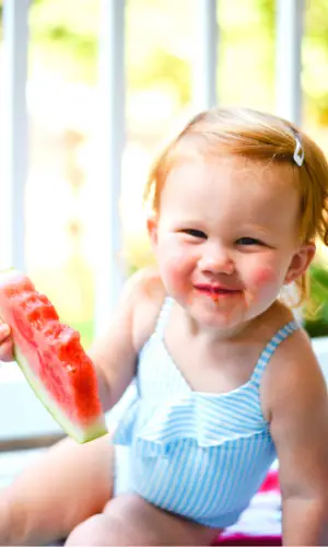 Baby girl eating watermelon