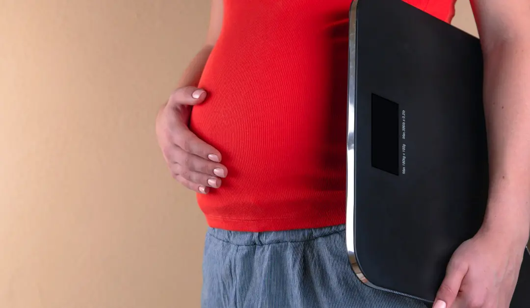 Pregnant woman with weighing scale