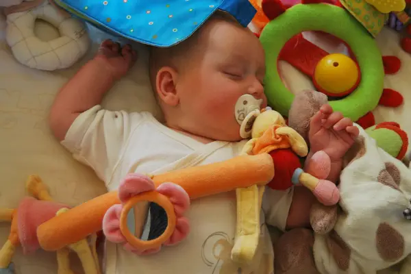 sleeping baby surrounded by toys