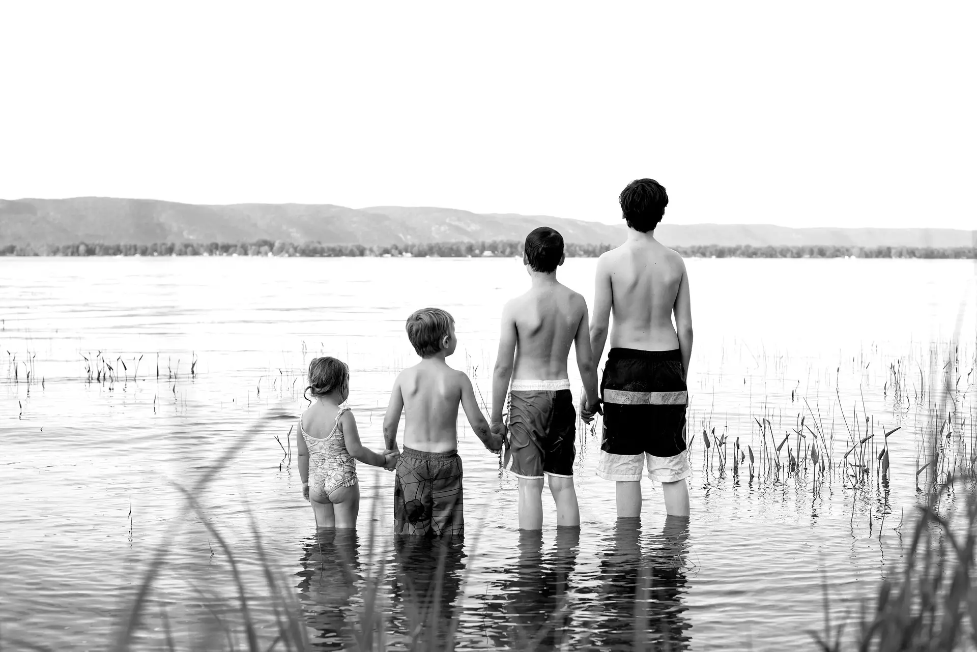 siblings standing in a lake