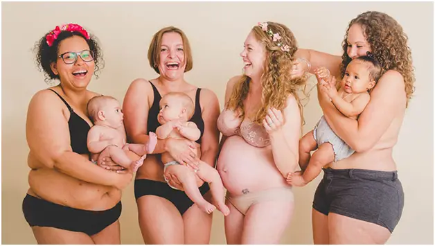 Pregnant woman surrounded by new moms and their babies