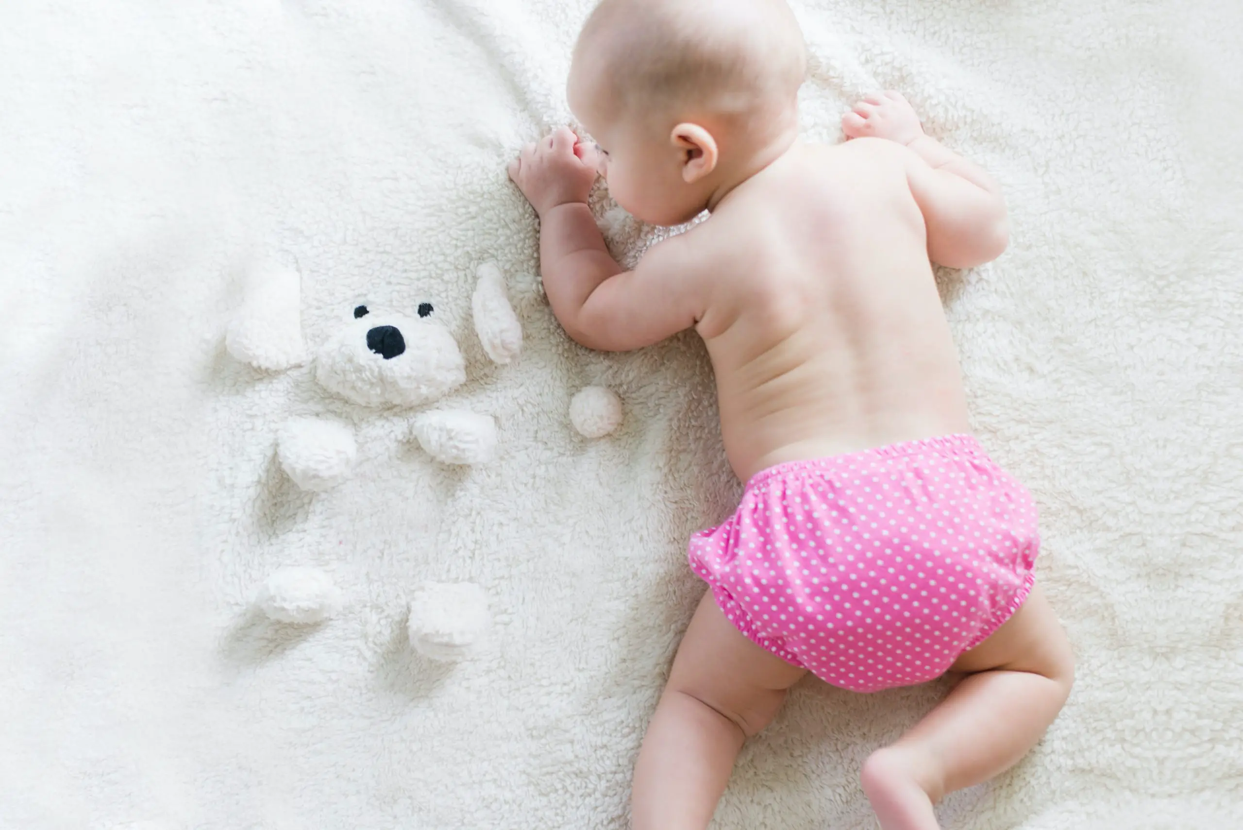 baby girl wearing a pink polka dot cloth diaper 