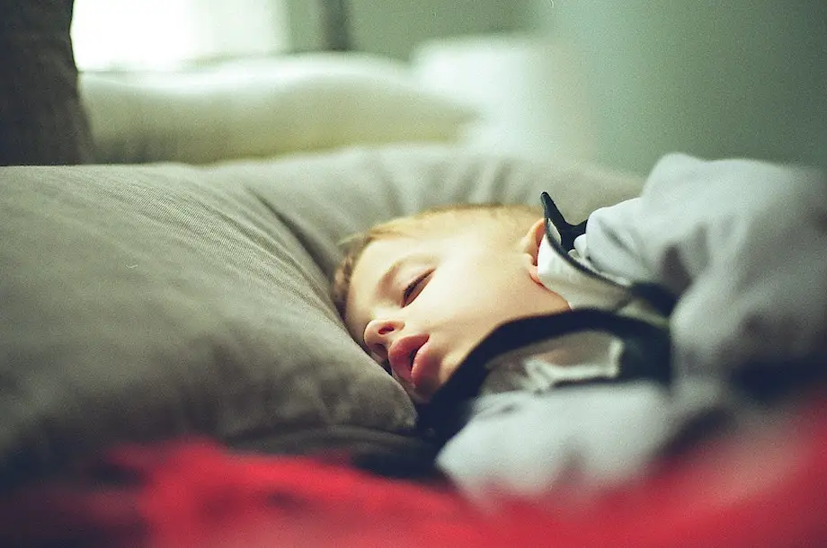 young boy sleeping soundly on his bed