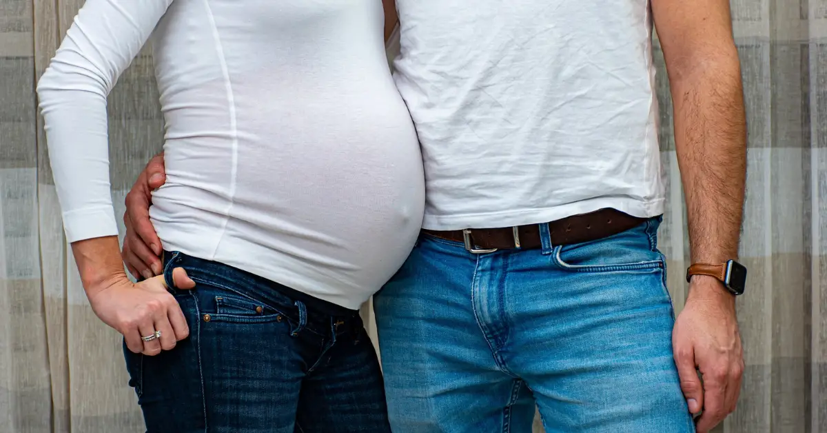 pregnant couple in white shirts